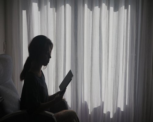 Cozy reading nook near a window with sheer curtains