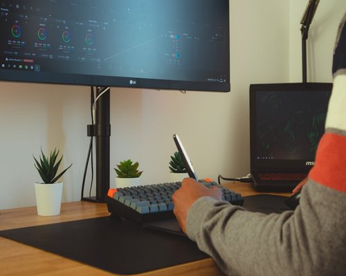 Person adjusting monitor brightness in home office